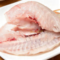 Raw sea bream fillet close-up showing firm white and pink flesh